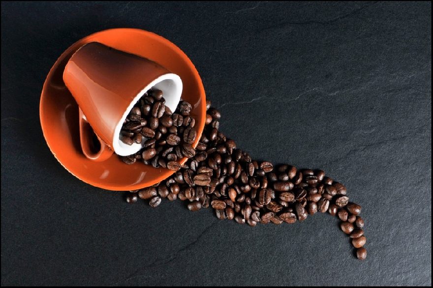 Kaffetasse mit Kaffeebohnen ausgeschüttet